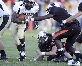 William D Lewis|The Vindicator Harding's Demond Hymes gets past Howland's Tony Osborne and Dan Russell during 1 rst qtr action Friday at Howland.