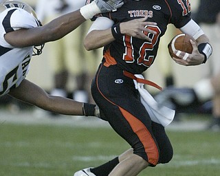William D Lewis|The Vindicator Howland QB Tim Parana tries to elude a Raider defender.