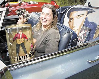 Tracy Miller of Liberty shows off Elvis memorabilia while sitting in the 1968 Cadillac DeVille she was showing at the festival in Church Hill Park in Liberty on Sunday. The event included music, food and a car show.
