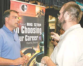 Job seekers, top, lined up for the Oh-Penn Interstate Region 2010 Job Expo on Wednesday. More than 5,000 mostly unemployed workers from Mahoning, Columbiana, Trumbull, Mercer and Lawrence counties crowded the Covelli Centre to meet with employers and explore job and training opportunities. Phillip McIntire, above right, of Sharpsville, Pa., talks with V&M Star maintenance manager David Giancola about openings for electricians at the company’s new steel mill in Youngstown.
