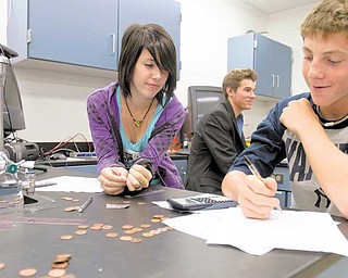 Junior Amanda Carlisle and sophomore Austin Beil practice taking precise measurements to determine the thickness of a penny and using indirect measurements to find the thickness of aluminum foil during chemistry class at Poland Seminary High School. After four years, all fi ve of the high school’s science labs have been renovated.