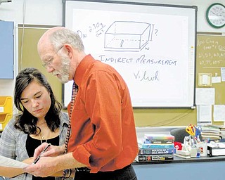 Chemistry teacher William Snyder helps junior Desiree Zepeda with a question during chemistry class at Poland Seminary High School. The instructional drawing projected in the background was created with one of the SMART Boards found in all fi ve of the high school’s science labs.