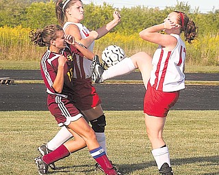 Alyssa Schauer, right, of Columbiana, attempts to kick the ball, as teammate Carolyn Gallo, center, and Katelin Smith (15) of South Range battle for position during Wednesday’s soccer match in Columbiana. South Range won 3-0.