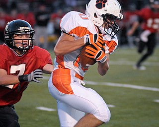 Howland WR Matt Hayes slips the tackle of Canfield's (7) Mike Ross after a short reception during their game on Friday. Photo/Mark Stahl