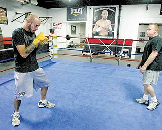 Kelly Pavlik shadowboxes in the ring as his trainer, Jack Loew, looks on Wednesday at the Southside Boxing Club.