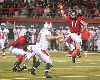 FITCH - Quarterback (10) Kyle Ohradzansky tries to elude (11) Shane Stevens and (20) Antoine Cox during their game Friday night in Austintown. - Special to The Vindicator/Nick Mays