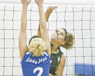 Mineral Ridge’s Paige Rassega spikes the ball as Jackson-Milton’s Ashley Staton (2) defends during Monday’s match in North Jackson. Mineral Ridge remained unbeaten in 10 matches with a three game victory.