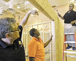Choffi n Career and Technical Center construction-technology students Jhordan Jackson, center, and Laquail Brooks, both juniors, under instruction from teacher Kevin Sinkele , left, work on a house for Habitat for Humanity of Mahoning County.