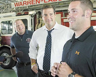 Jeremy Rodgers, right, a laid-off Warren firefighter, is all smiles after an announcement from U.S. Rep. Tim Ryan of Niles, D-17th, center, that the city fire department is getting a nearly $5 million federal grant to recall laid-off firefighters and hire new ones. At left is Marc Titus, president of the firefighters union. The announcement was made Wednesday at the central fire station in downtown Warren.