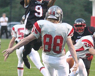 FOOTBALL - (9) Dennis Williams goes for the block as (88) Paul Zigmont tries to get the punt off Friday night in Campbell. - Special to The Vindicator/Nick Mays
