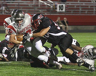 FOOTBALL - (30) Zach Miller leans for yardage as (50)David Benedis maks the stop Friday night in Campbell. - Special to The Vindicator/Nick Mays