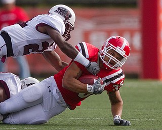 Geoffrey Hauschild|The Vindicator.Southern Illinois' Korey Lindsy (21) and an unidentifiable teamate bring down Youngstown State University's Jamaine Cook (35) during the first quarter of a game at Youngstown State University's Stambaugh Stadium on Saturday afternoon.