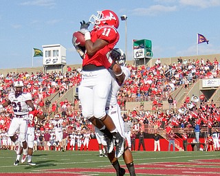 Geoff Hauschild|The Vindicator.YSU's Kevin Watts (11) successfully snags the ball, while defended by Souther Illinois' E.J. Clark (9), scoring a touchdown during the second quarter and tying the game for the Penguins at 14.