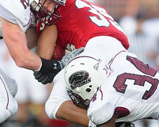 Geoffrey Hauschild|The Vindicator.Southern Illinois' Brad Briggs (12) and Jayson DiManche (34) bring down YSU's Jamaine Cook (35) during the second half of a game at Youngstown State University's Stambaugh Stadium on Saturday afternoon.