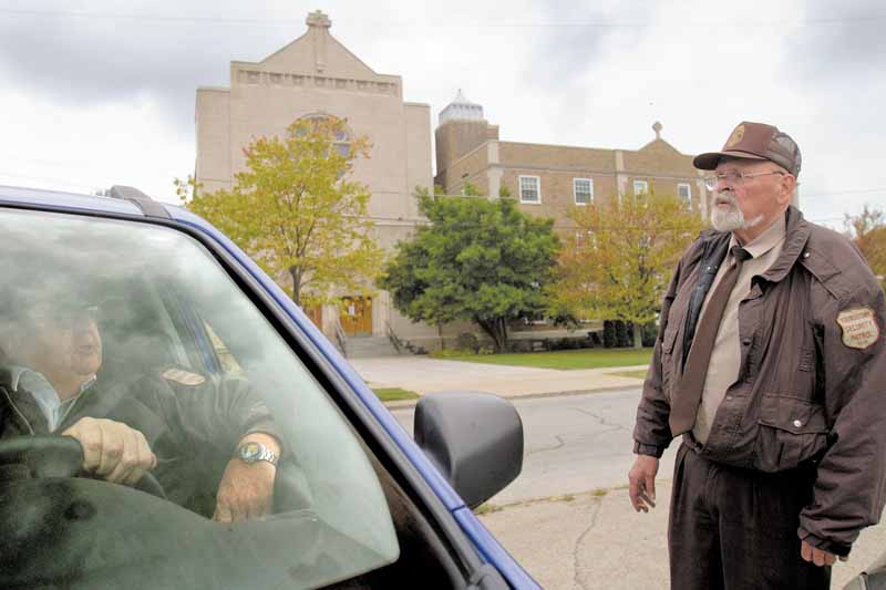 Bob Jacobs, of Youngstown, and Wally Heck, of New Springfield, talk Sunday morning while working security outside St. Dominic Church, 77 E. Lucis Ave. Thomas J. Repchic, 75, and Jacqueline Repchic, 74, two St. Dominic parishioners, were shot Saturday afternoon near the intersection of Southern Boulevard and Philadelphia Avenue. Thomas Repchic died of his injures, and his wife is in the hospital. They’re the second and third St. Dom’s members to fall victim to a shooting this year.
