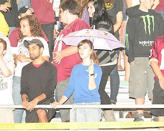 Dorie Chevlen a senior from Liberty High School trying to keep dry while cheering on the Leopards