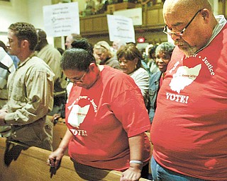 Among those praying at Monday night’s Community Congress at Trinity United Methodist Church downtown were Gladys Bowers and Thomas Swanson, attending with a group from Union Baptist Church.