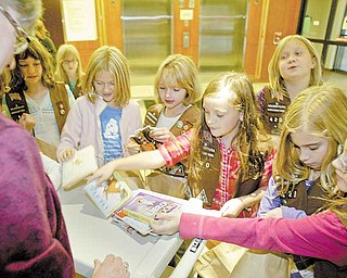 DeAnne Bunevich, child-life specialist at Akron Children’s Hospital, accepts a donation of books from Girl Scout Troop 420 of Canfield. Bunevich said she suggested that the troop donate small, chunky pictures books with cardboard pages for younger children.