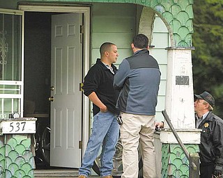 Police search the home at 537 Garfield St., off Glenwood Avenue, Tuesday afternoon. One man was taken into custody in the shooting death of Thomas J. Repchic, 74.