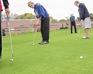 Geoffrey Hauschild|The Vindicator.McDonald High School golf team members' Zach Gillespie, Jason White, and Brandon Pustay practice their putting at the Mahoning Country Club during a practice tuesday evenning..