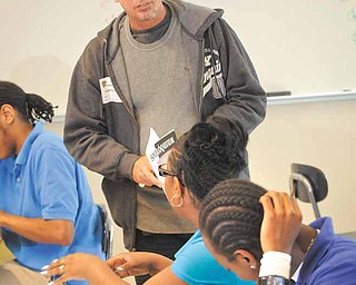 Cuban poet Raul Hernandez Ortega works with students in Jennifer Walker’s advanced placement literature/composition class Wednesday at Youngstown’s East High School.