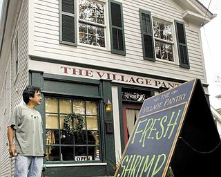 William D Lewis|The Vindicator Ron Eiselstein, owner of Village Pantry in Poland stands near a sign infront of his building advertising fresh shrimp grown in ponds in Youngstown.