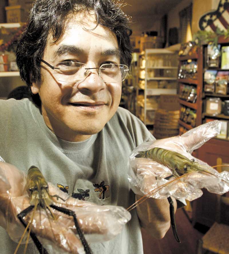 Ron Eiselstein, owner of Village Pantry in Poland, shows off fresh shrimp grown in ponds in Youngstown.