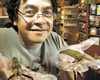 Ron Eiselstein, owner of Village Pantry in Poland, shows off fresh shrimp grown in ponds in Youngstown.