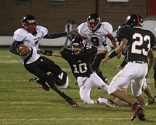 FOOTBALL - Lester Hughes tries to escape the grasp of (10) Zach Penick Friday night in Salem. (9) Dennis Williams and (23) Mike Crittenden get in on the play. - Special to The Vindicator/Nick Mays