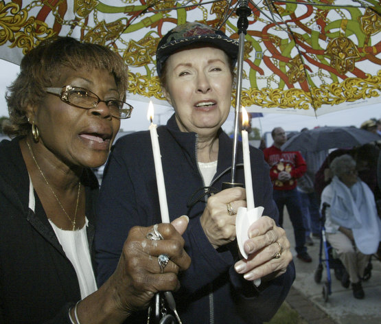 William d Lewis The Vindicator  Emma Nelson, left, of youngstown and sue Vitale of Boardman hold candles at a rally Saturday outside St Dom's church. The had never met before the rally.