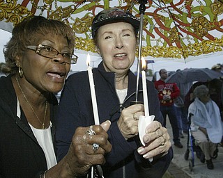 William d Lewis The Vindicator Emma Nelson, left, of youngstown and sue Vitale of Boardman hold candles at a rally Saturday outside St Dom's church. The had never met before the rally.