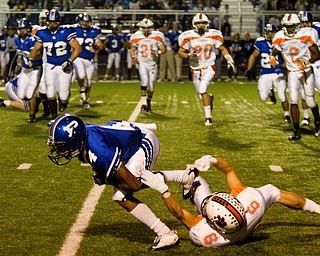 Geoffrey Hauschild|The Vindicator.Howland's Denny Pozega (6) brings down Poland's Darius Patton (4) during the first quarter of a game at Poland High School on Friday evening.