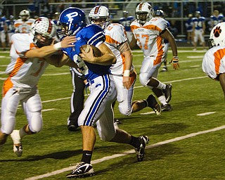 Geoffrey Hauschild|The Vindicator.Poland's Colin Reardon (9) is stopped by Howland's Zac Wilson (7) during the first quarter of a game at Poland High School on Friday evening.