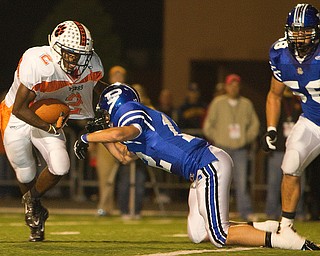 Geoffrey Hauschild|The Vindicator.Howland's Tony OSborne (2) makes his way down field but is tripped up by Poland's Alex Argeras (12) during the second quarter of a game at Poland High School on Friday evening.