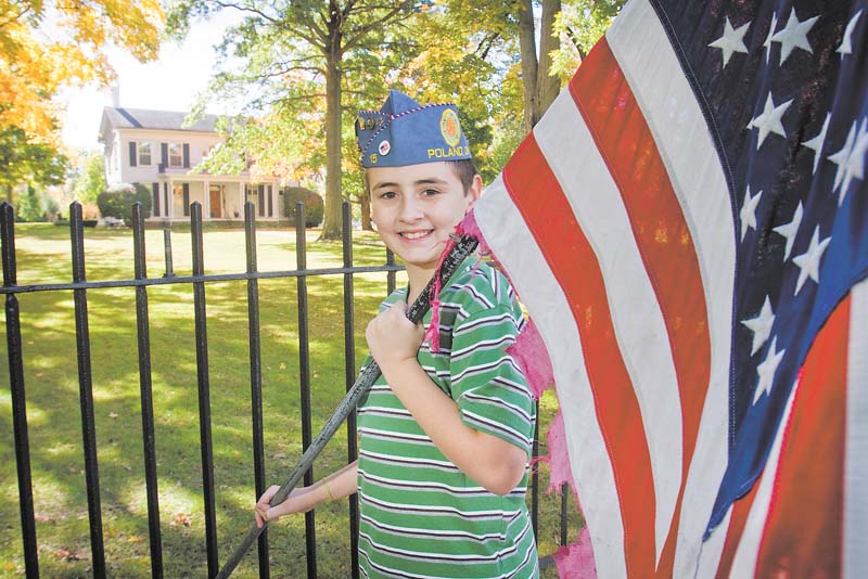 Jeffrey Vrabel Jr., 11, of Poland, displays one of the tattered American flags that will be retired as part of the Flags Over Poland fundraiser conducted by the Sons of the American Legion Squadron 15. The group hopes that 28 new American flags will be in place in front of Poland Village Hall on South Main Street by Veterans Day, Nov. 11..