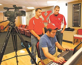 YSU students Zack Humphries, back left, and Pat Andrews, back right, are the anchors for Penguin Rundown, a weekly highlights show on Penguin athletics. Humphries is an Ursuline High graduate, while Andrews graduated from Canfield High School. Jon Raidel, seated, is the executive producer. He is a graduate of Girard High School.