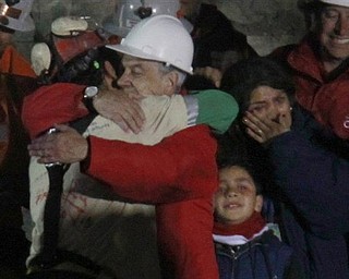 Chile's President Sebastian Pinera embraces miner Florencio Antonio Avalos Silva after he was rescued from the collapsed San Jose gold and copper mine where he was trapped with 32 other miners for over two months near Copiapo, Chile, Tuesday Oct. 12, 2010. at the San Jose Mine near Copiapo, Chile Wednesday, Oct. 13, 2010. Next to Pinera Avalos wife and daughter.(AP Photo/Roberto Candia)