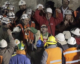 Chile's President Sebastian Pinera, center top, cheers as rescued miner Mario Sepulveda Espina, center, salutes after being rescued from the the collapsed San Jose gold and copper mine where he was trapped with 32 other miners for over two months near Copiapo, Chile, early Wednesday Oct. 13, 2010.(AP Photo/Jorge Saenz)