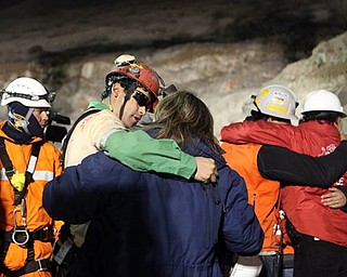 In this photo released by the Chilean government, miner Florencio Avalos, second left, hugs a relative after he was rescued from the collapsed San Jose gold and copper mine where he was trapped with 32 other miners for over two months near Copiapo, Chile, early Wednesday, Oct. 13, 2010. (AP Photo/Hugo Infante, Chilean government)