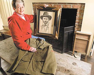 Colette Chuey displays a print of Ulysses S. Grant as she holds the jacket of an authentic World War I uniform at the Barnhisel House in Girard. The Girard Historical Society is having a Cemetery Walk to raise money for the upkeep of the house, which is a museum that features antiques from the 1800s.