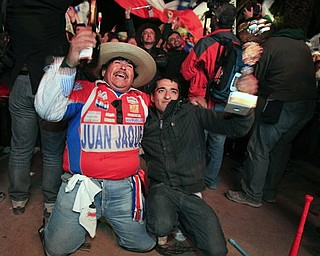People celebrate the end of the successful rescue operation that freed 33 trapped miners from the San Jose mine in Copiapo, Chile, Wednesday Oct. 13, 2010. The 69-day underground ordeal reached its end Wednesday night after 33 trapped miners were hauled up in a cage through a narrow hole drilled through 2,000 feet of rock. (AP Photo/Martin Mejia)