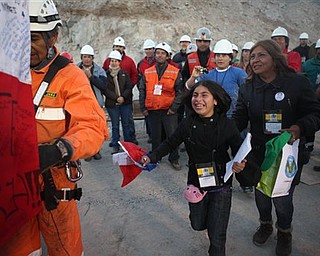 In this photo released by the Chilean government, family members approach the capsule containing miner Richard Villaroel as he is rescued from the collapsed San Jose gold and copper mine where he had been trapped with 32 other miners for over two months near Copiapo, Chile, Wednesday Oct. 13, 2010. (AP Photo/Hugo Infante, Chilean government)