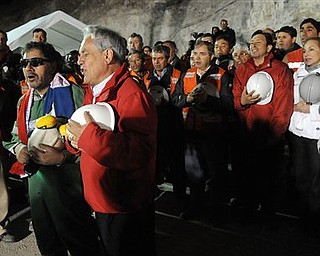 In this photo released by the Chilean Presidential Press Office, the last miner to be rescued, Luis Urzua, front row left, sings Chile's national anthem with Chile's President Sebastian Pinera and rescue workers after he was rescued from the collapsed San Jose gold and copper mine where he had been trapped with 32 other miners for over two months near Copiapo, Chile, Wednesday Oct. 13, 2010. The 69-day underground ordeal reached its end Wednesday night after 33 trapped miners were hauled up in a cage through a narrow hole drilled through 2,000 feet of rock. (AP Photo/Alex Ibanez, Chilean Presidential Press Office)