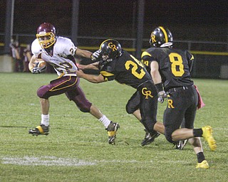 FOOTBALL - (22) Phillip Arsuffi tries to get away from (24) Craig Lower and (8) Jacob Danks Friday night at Crestview. - Special to The Vindicator/Nick Mays