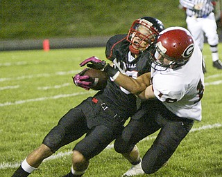 William D. Lewis|The Vindicator Girard's Bryan Daugherty tackles Red Devil's Richard Bledsoe during 1 rst half action Friday at Campbell.