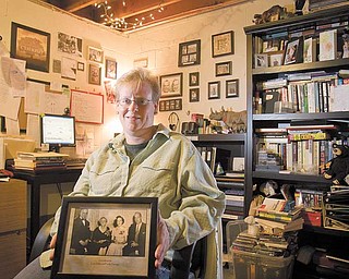 Kristi R. McPherson-Burns of Austintown shows off her books and notes on genealogy. The photograph that she is holding is of her maternal great-grandparents and maternal grandparents..