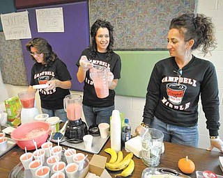 Campbell Middle SchoolÕs Smoothie Moms, from left, Charlet Hankey, Stella Opencar and Anna Koulianos, mix up batches of strawberry and banana smoothies. Monday was the first day of their weeklong bake sale at the school. They have their sales one week a month..