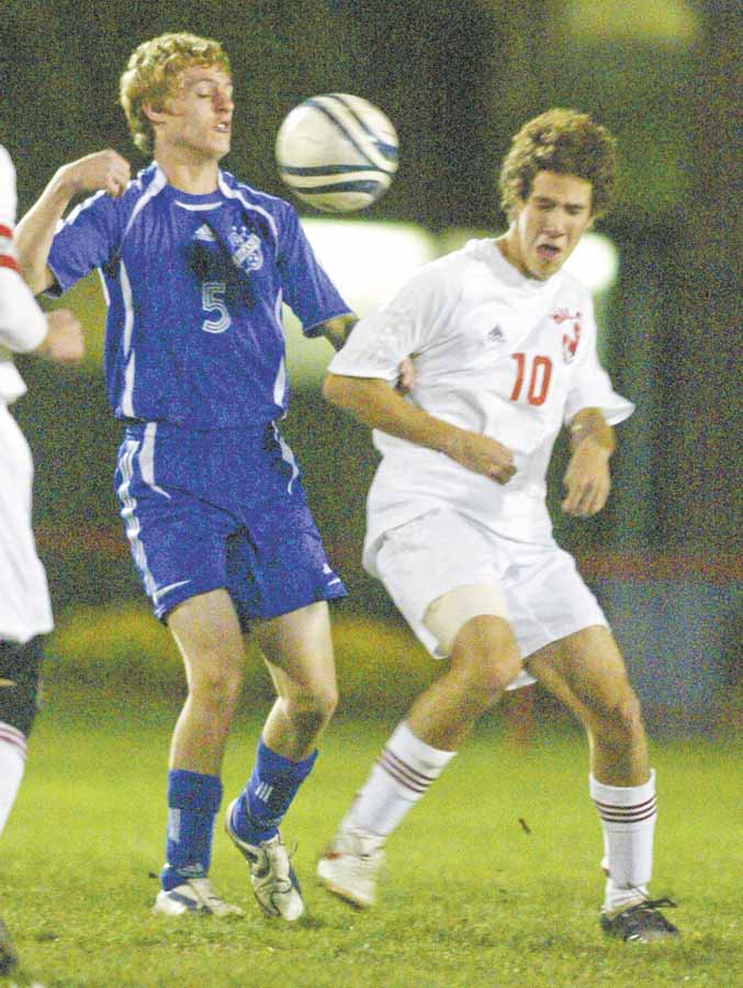 Poland High’s Dan Montgomery, left, and Niles’ C.J. Cicero go for the ball during Tuesday’s Division II boys soccer tournament game at Bo Rein Stadium in Niles. The Red Dragons advanced with a 3-2 victory.