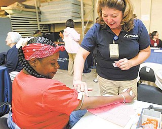 Sylvia Bradley, left, of Youngstown gets a blood screening by Laura Daily, a phlebotomist at St. Elizabeth Health Center, at Project Connect. Thursday’s event at the Rescue Mission of the Mahoning Valley on Glenwood Avenue was to improve access to services and housing for the homeless and near-homeless.