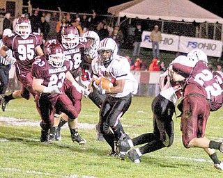 FOOTBALL - (14) Taron Montgomery gets away from the Boasrdman defense including (23) Nate Provanca and (58) Bergen Brown during their game Thursday night. - Special to The Vindicator/Nick Mays